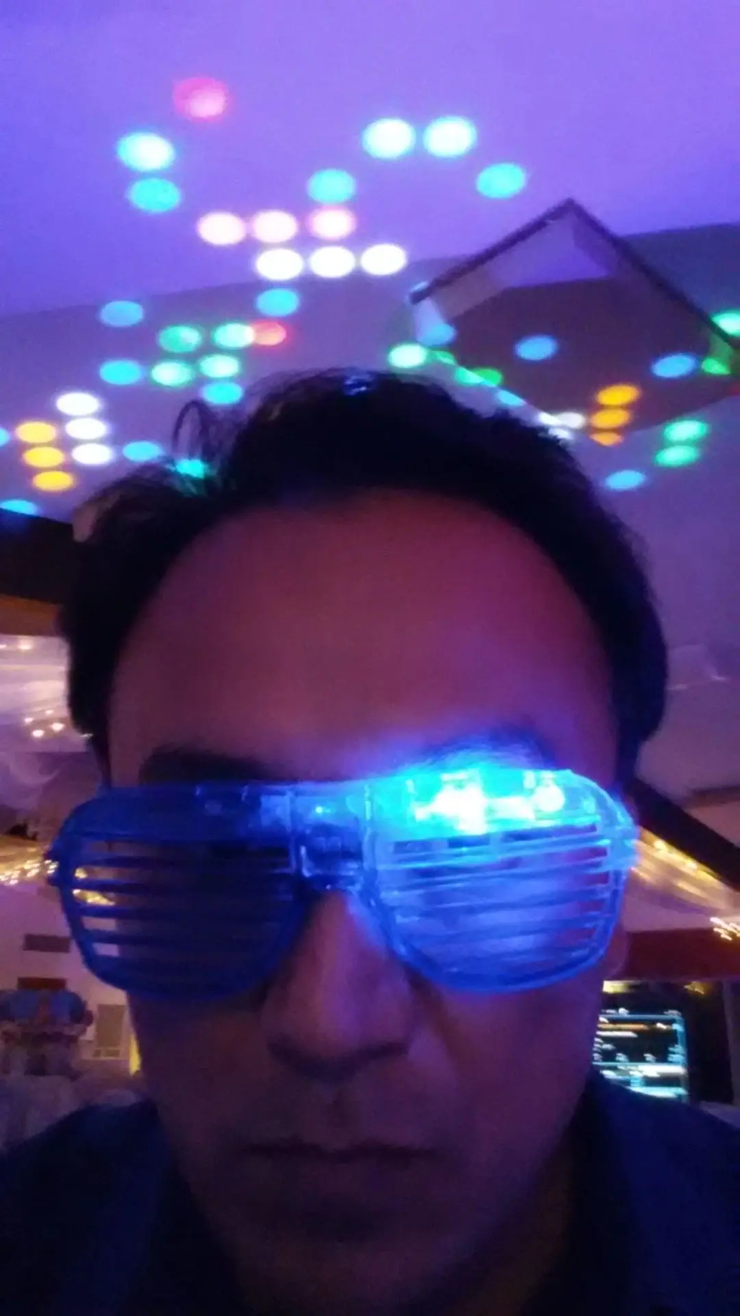 rs=w_1280 (69) A person wearing blue LED shutter glasses under colorful disco lights with a serious expression.